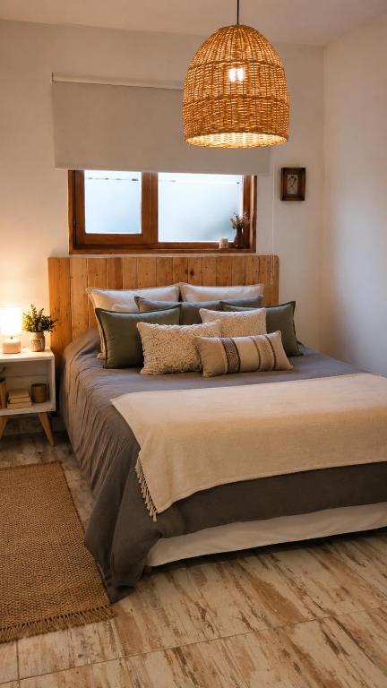 a bedroom with a large bed with a chandelier at Casa cronopio in Ushuaia