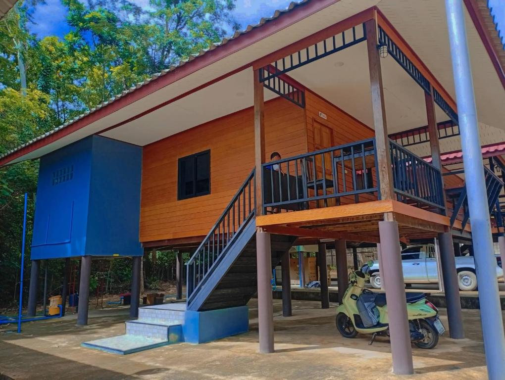 a house with a motorcycle parked in front of it at hadya home in Ko Yao Noi