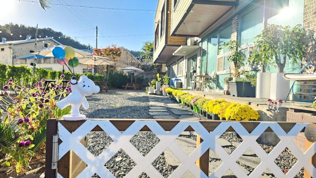 a white fence with a figurine on it next to a street at Stay Suncheon in Suncheon