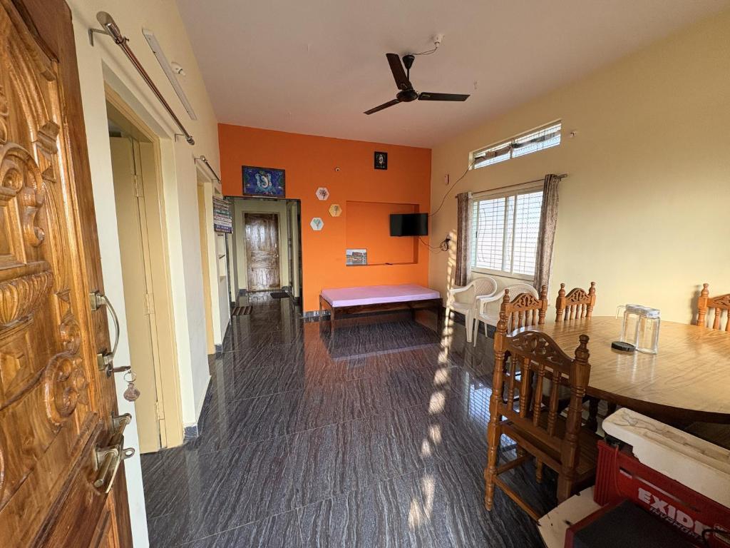 a living room with orange walls and a table at Cave View Homestay in Badami