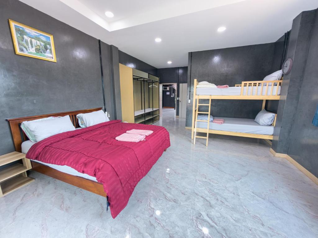 a bedroom with a bed and two bunk beds at NJ HOME Pool Villa in Ban Phe