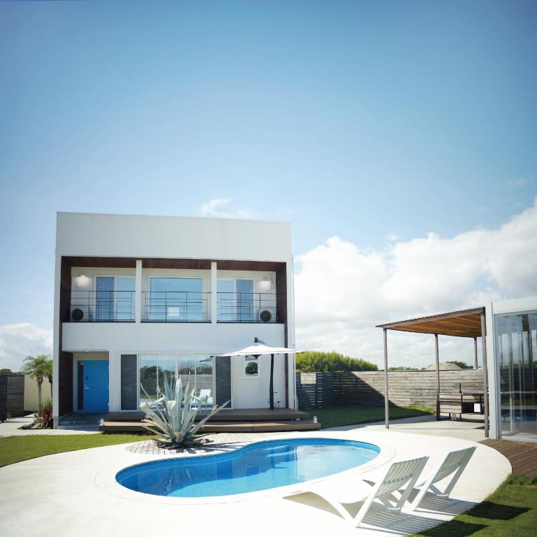 a house with a swimming pool and two chairs at VILLA Seamu 九十九里 家族と愛犬で楽しむサウナとプール ガラス貼りBBQルーム付き高級ガーデンヴィラ in Kujukuri