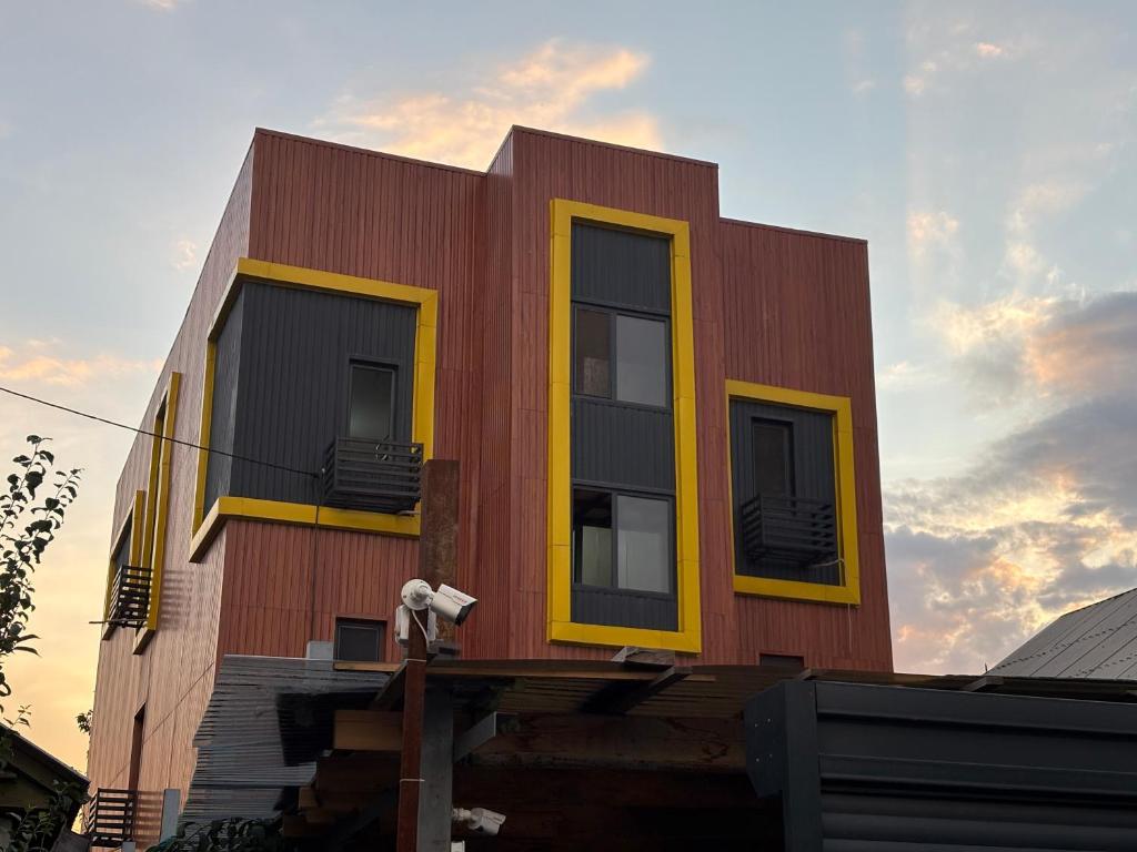 a building with yellow windows on the side of it at Kushtar in Bishkek