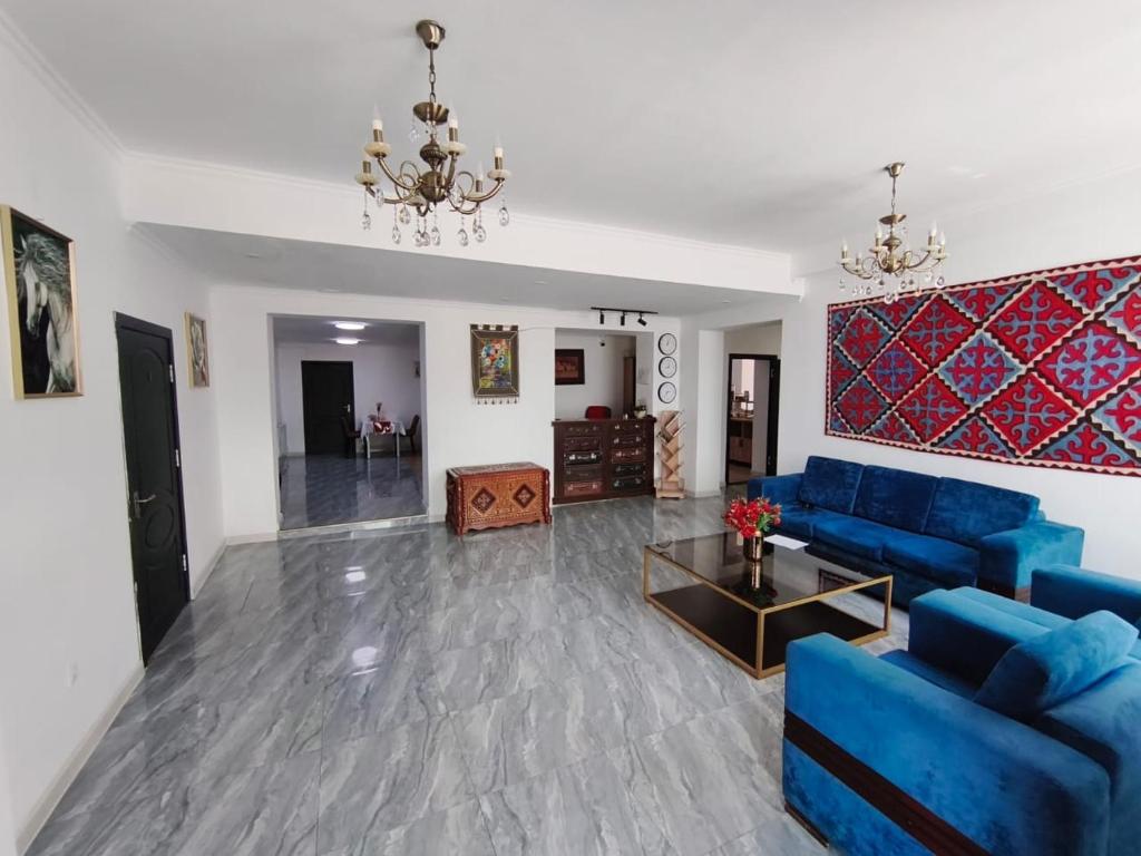 a living room with a blue couch and a table at Archa Hotel Kochkor in Kochkorka