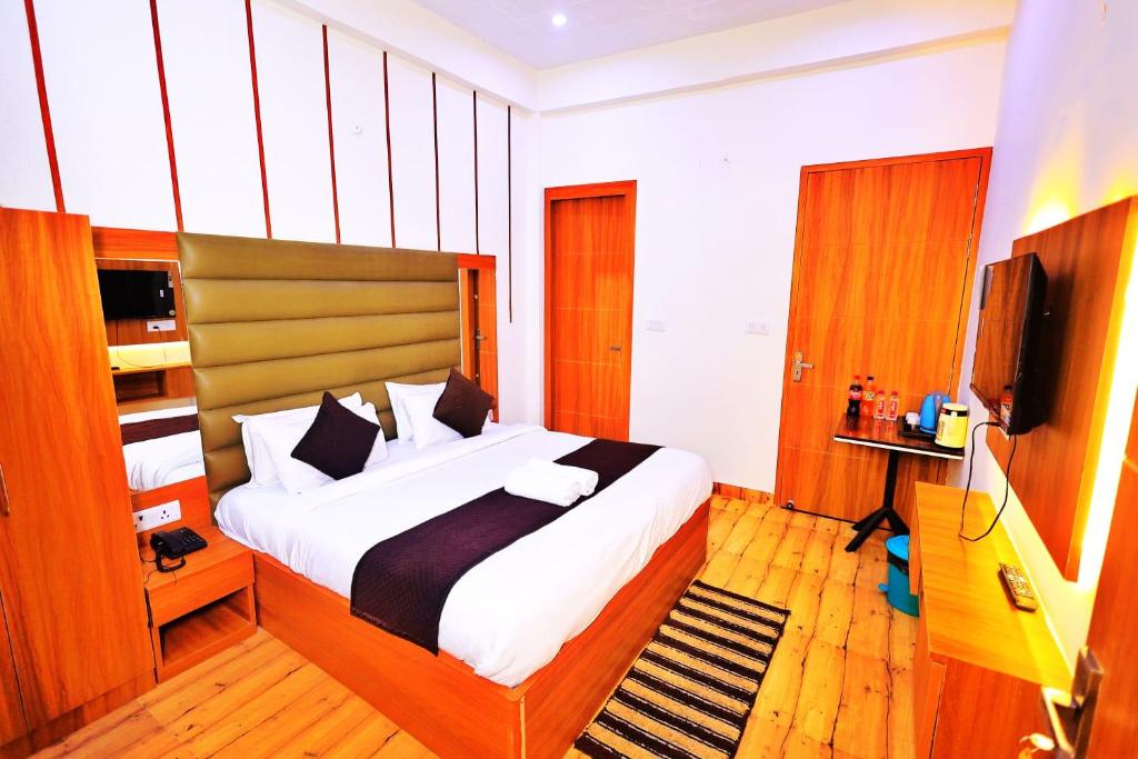 a bedroom with a large bed and a television at Hotel Yuvan Palace - Agra in Tājganj