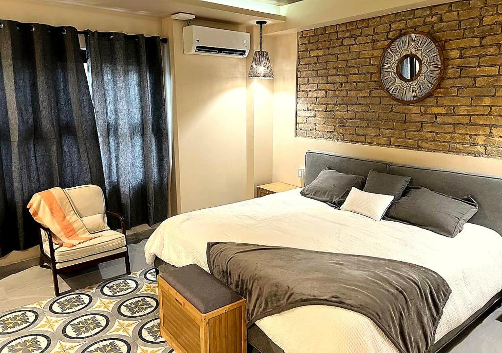 a bedroom with a large bed and a brick wall at Casa7Cielos in Monterrey
