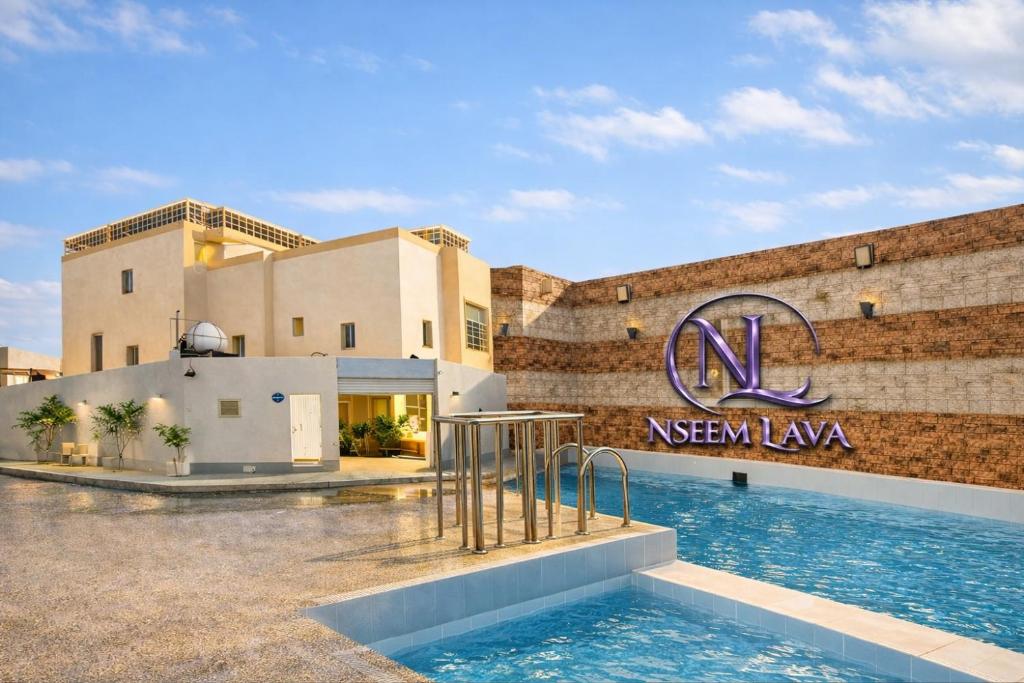 ein Hotel mit einem Schwimmbad vor einem Gebäude in der Unterkunft فيلا وشاليه نسيم لافا in Rayyis