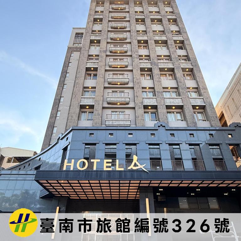a hotel building with a sign in front of it at Hotel A in Tainan