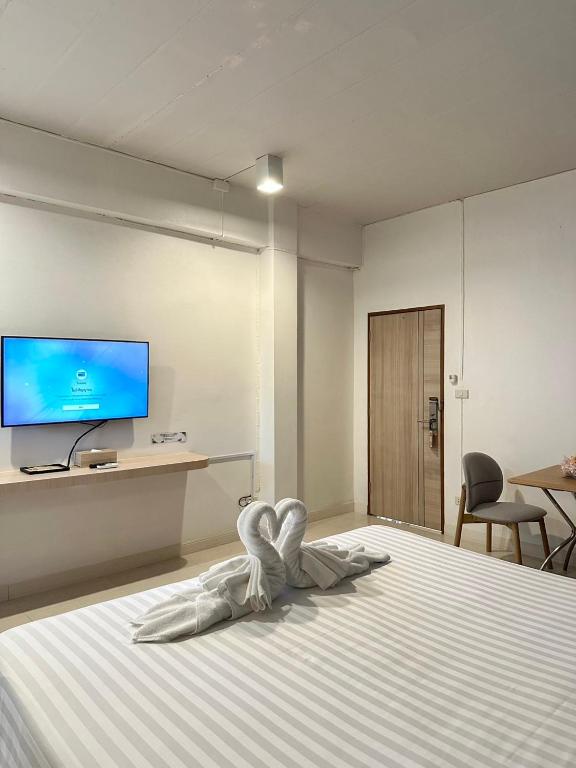a bedroom with a bed with a tv on the wall at House Hotel Walking Street Pattaya in Pattaya
