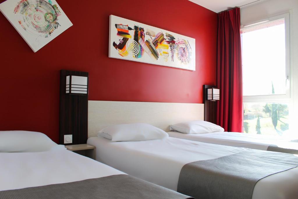 two beds in a room with red walls at The Originals City, Hôtel Pont Rouge (ex inter-hôtel), Carcassonne in Carcassonne