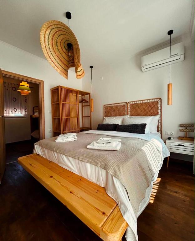 a bedroom with a large bed with a wooden bench at Homefeel2024 in Kavála