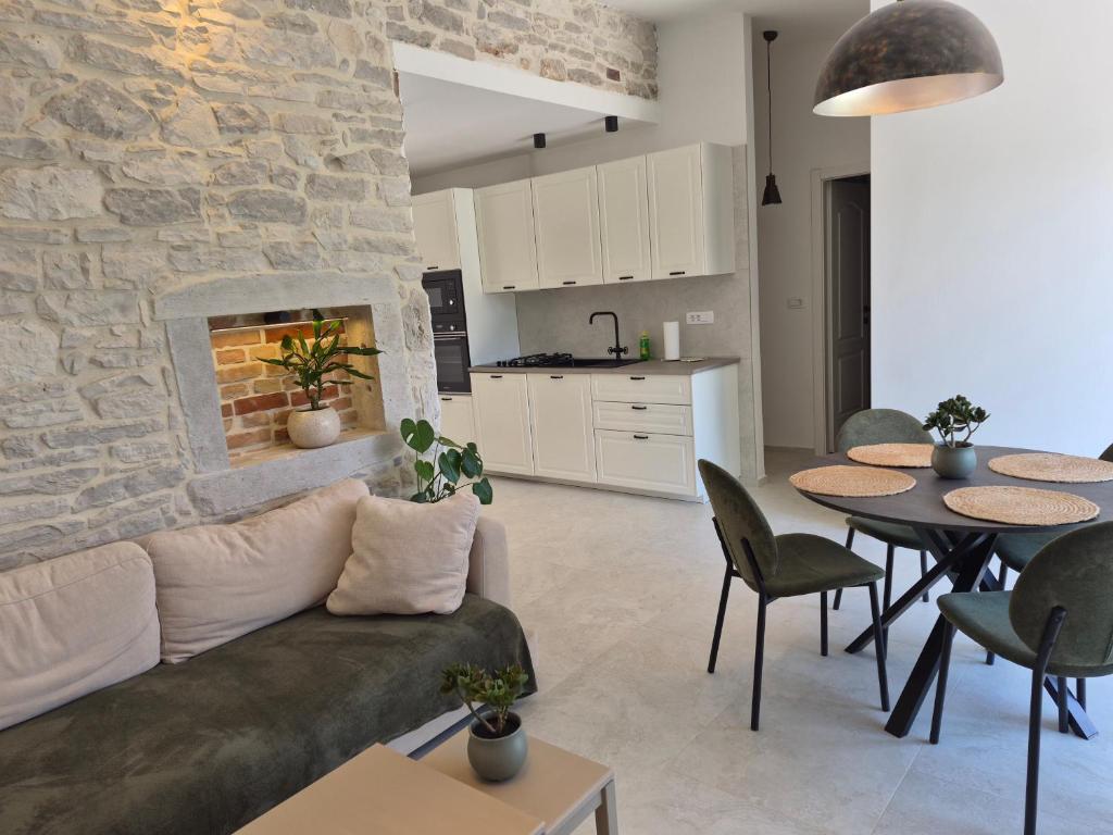a living room with a couch and a stone wall at Mareya Premium Stay in Poreč