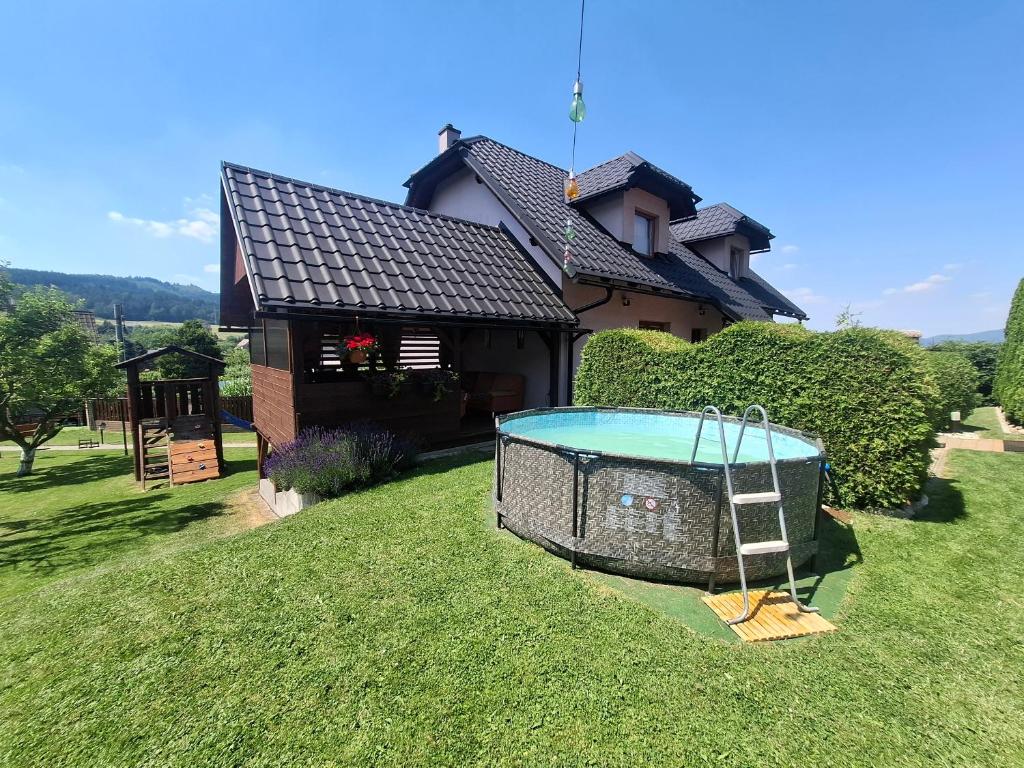 a house with a pool in front of a yard at Apartmány u tenisového kurtu in Mosty u Jablunkova