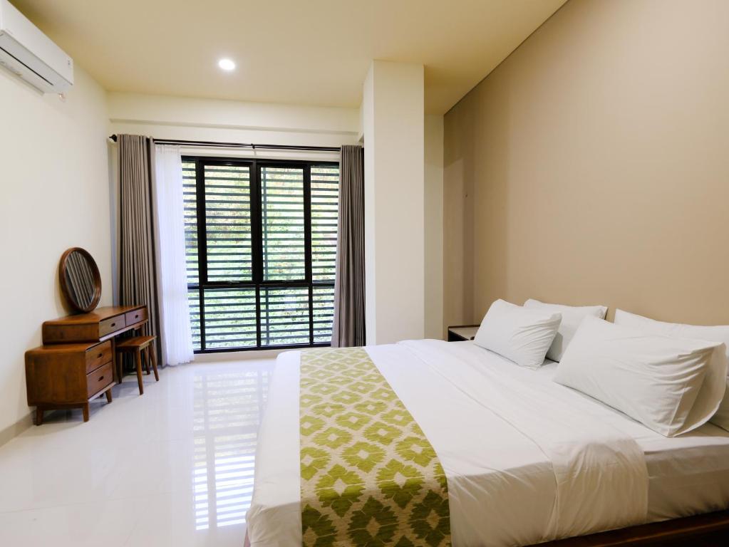 a bedroom with a large bed and a window at Apatto Bajo in Labuan Bajo
