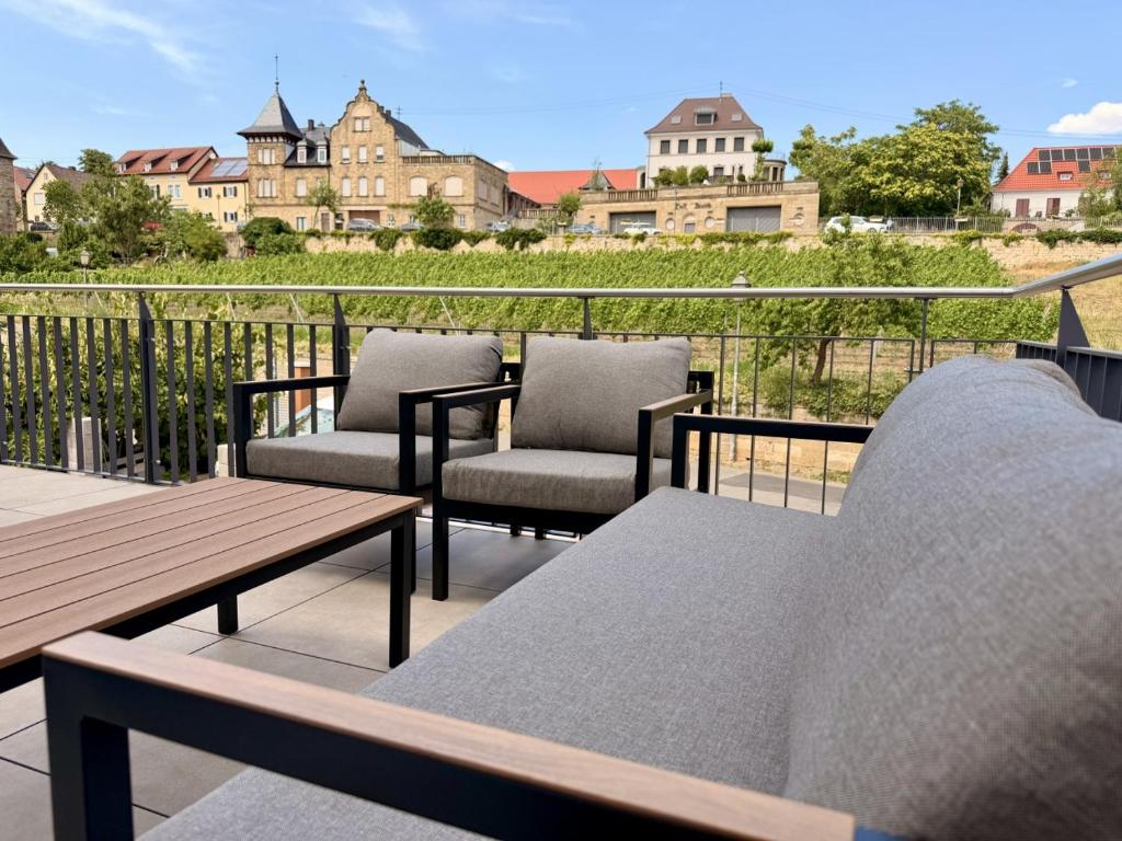 a patio with chairs and a table on a balcony at Gimmeldinger Haus in Neustadt an der Weinstraße