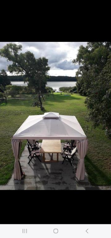 a picnic table with a large white umbrella at Poddasze nad jeziorem Piaski in Wolin