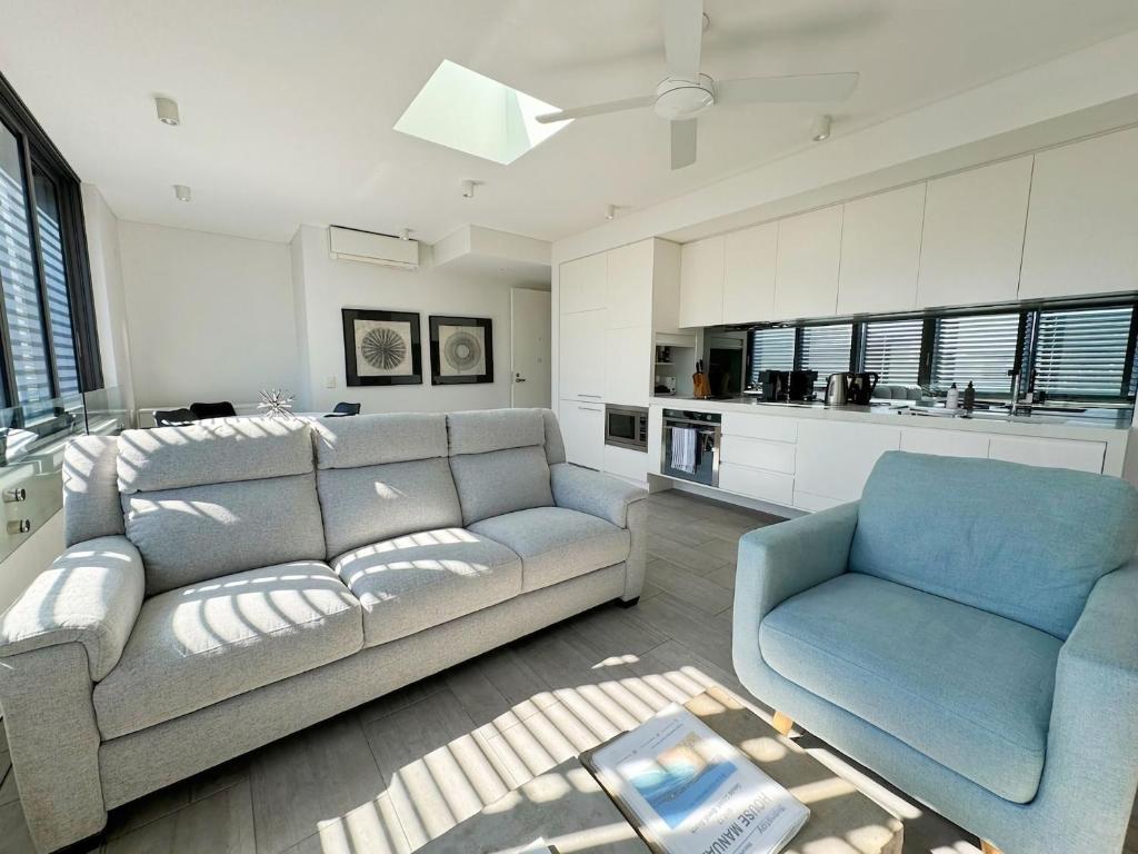 a living room with a couch and a chair at Bondi Beach Escape, Steps to Sand & Cafe in Sydney