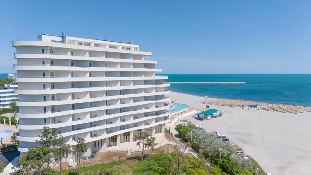 a large white building next to a beach at Mera Maris in Cap Aurora