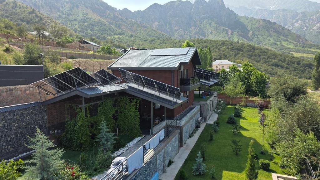 an aerial view of a building with mountains in the background at Panorama Lux Guest House in Chimgan