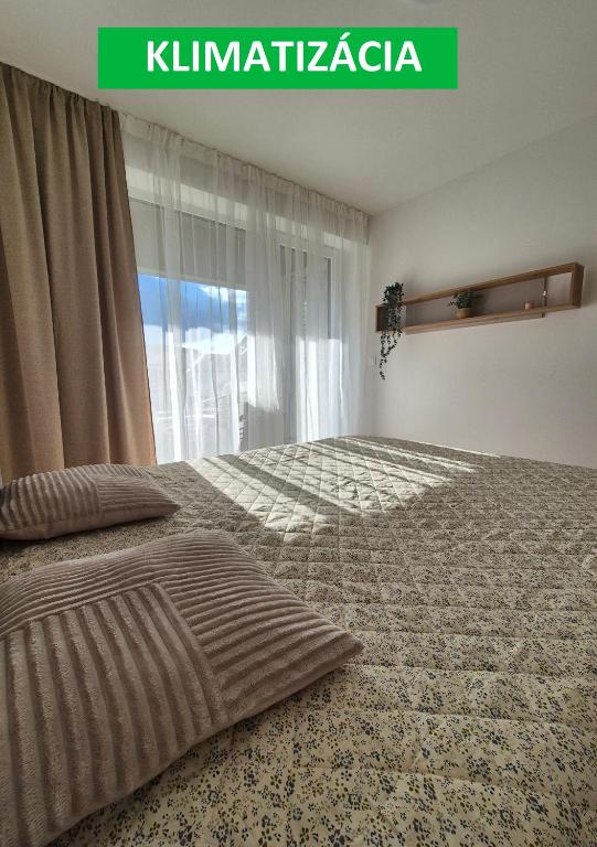 a bedroom with a bed and a window at Apartmány Koliba in Turčianske Teplice