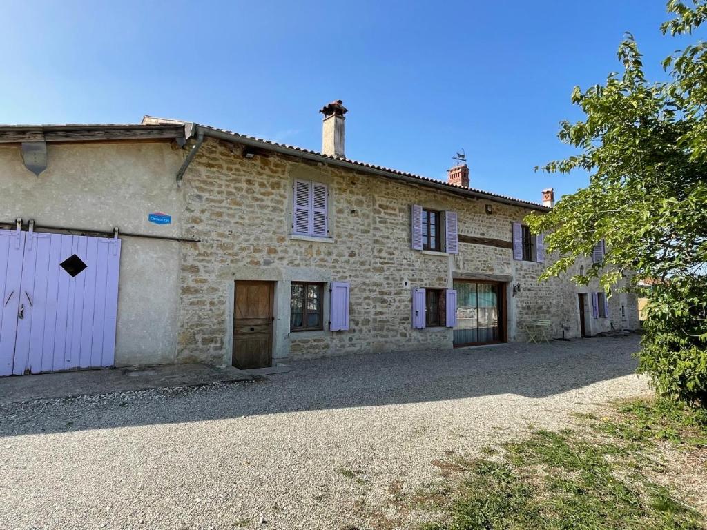 an old stone house with a driveway in front of it at Le Bellaton in Ambronay