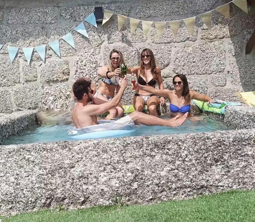a group of people sitting in a swimming pool at Pedacinho do Céu in Vieira do Minho