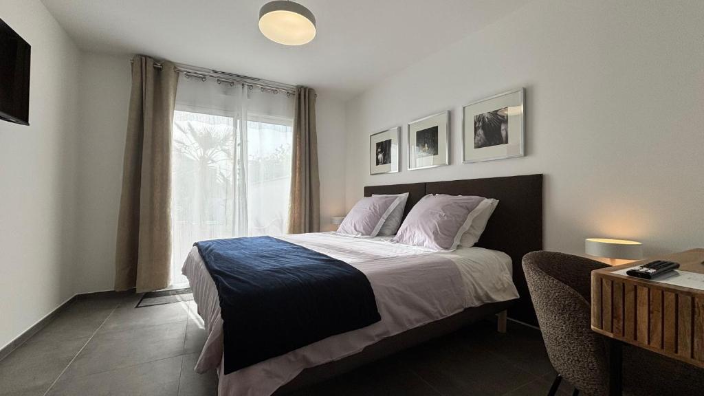 a bedroom with a large bed and a window at Villa Lagune in Les Sables-d'Olonne