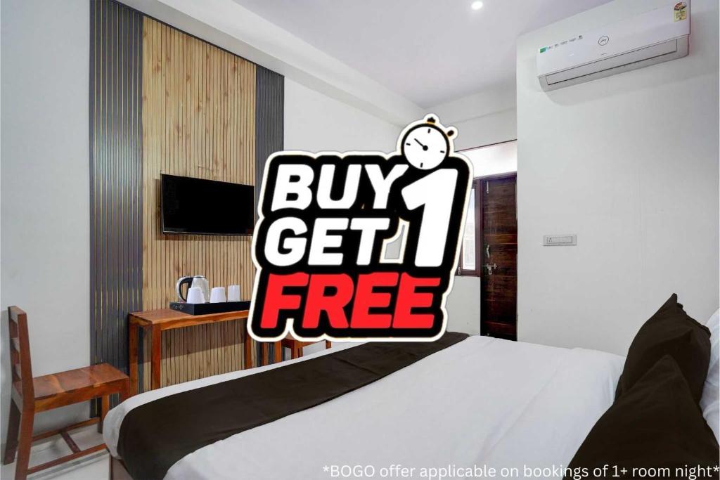 a bedroom with a bed with a buy get free sign at Townhouse Manipal University Highway King Bagru Formerly Golden Hotel in Jaipur