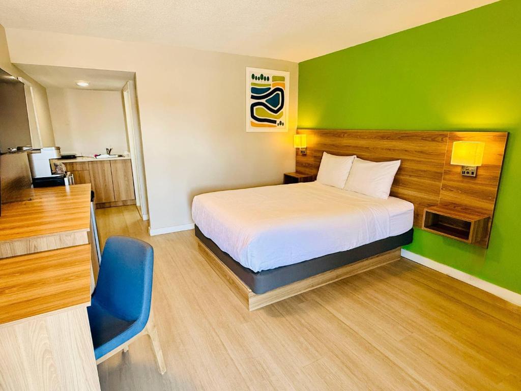 a bedroom with a bed and a green wall at Park Inn by Radisson, Quesnel in Quesnel