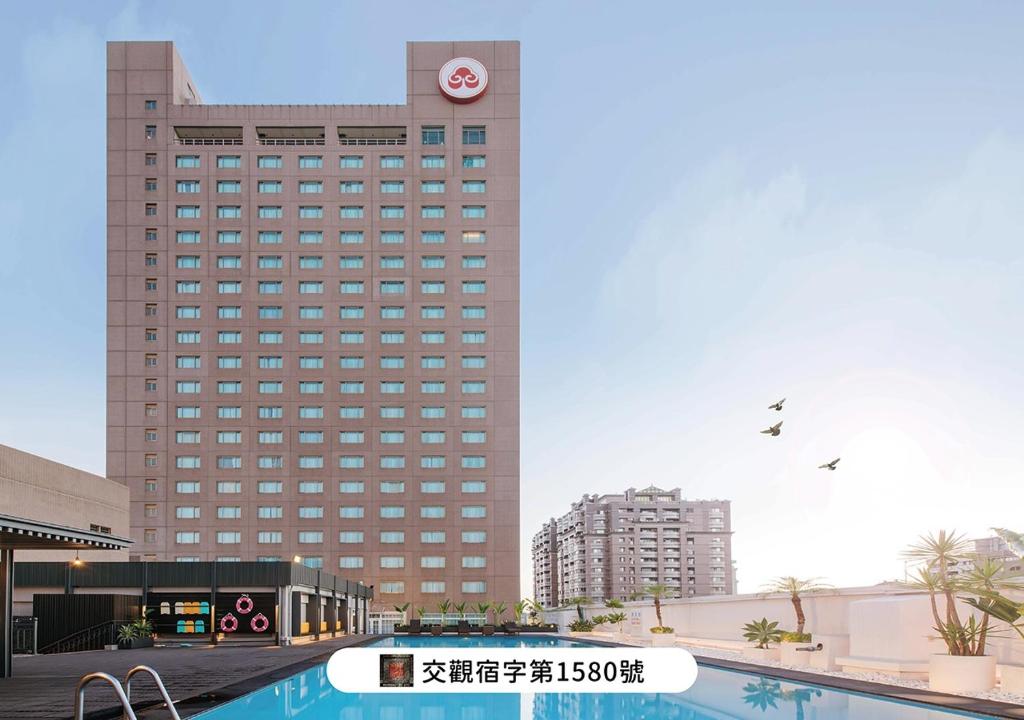 a large building with a clock on top of it at The Howard Plaza Hotel Kaohsiung in Kaohsiung