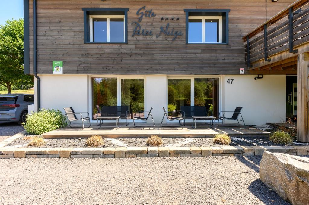 a building with chairs and tables in front of it at Gîte Perce Neige, Spa, Sauna in Gerbépal