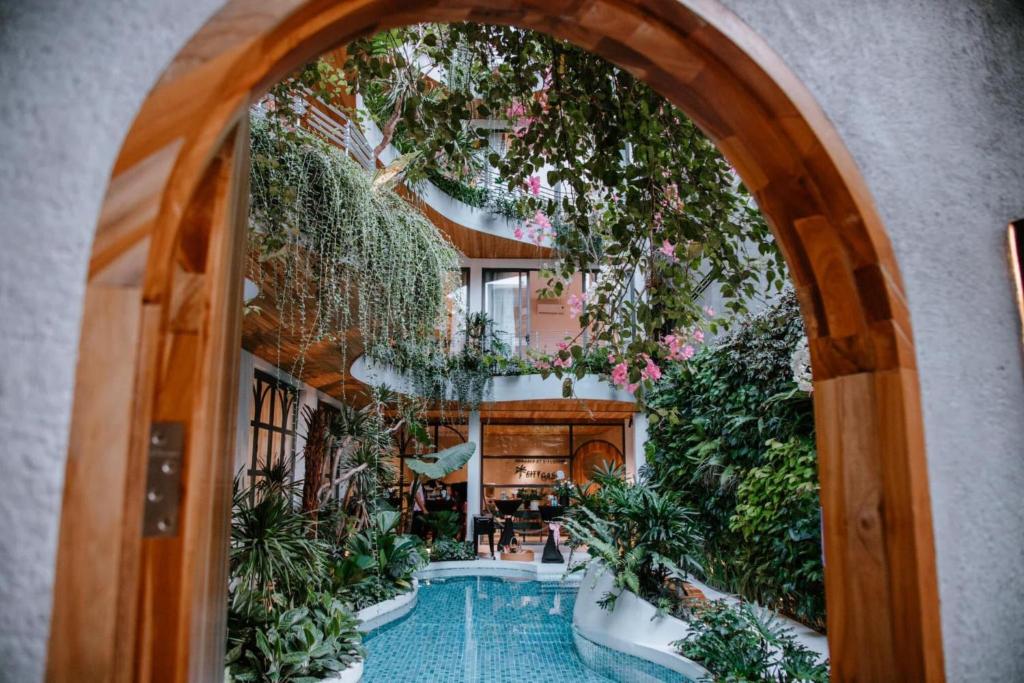 an archway in a building with a pool and plants at CityHouse VIBE City Oasis in Ho Chi Minh City