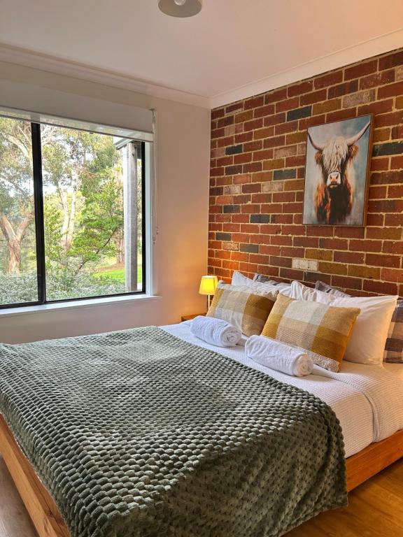 a bedroom with a large bed with a brick wall at Turicum AT Monkey Rock Winery & Cider in Parryville