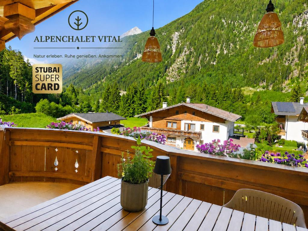 a table on a balcony with a view of a mountain at Alpenchalet Vital in Neustift im Stubaital