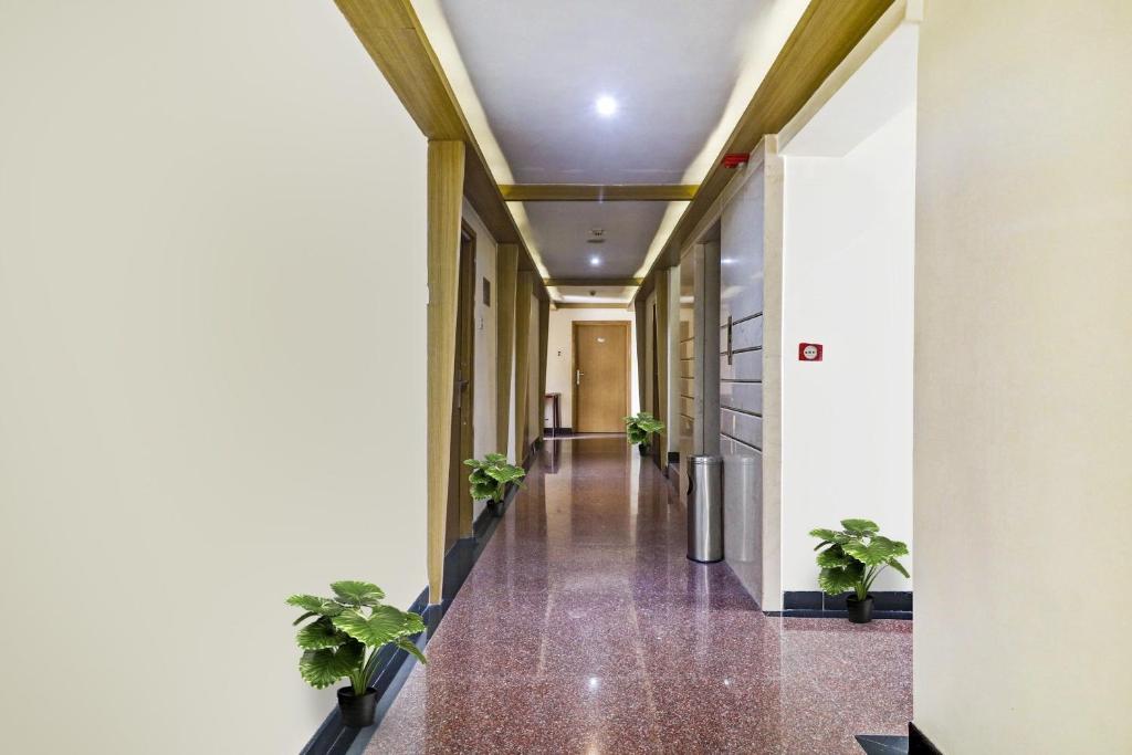 a hallway with potted plants in a building at Collection O THE CROWN HOTEL in Hyderabad