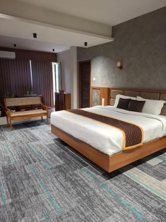 a large bedroom with a large bed and a piano at Windowind Resort in Koroth