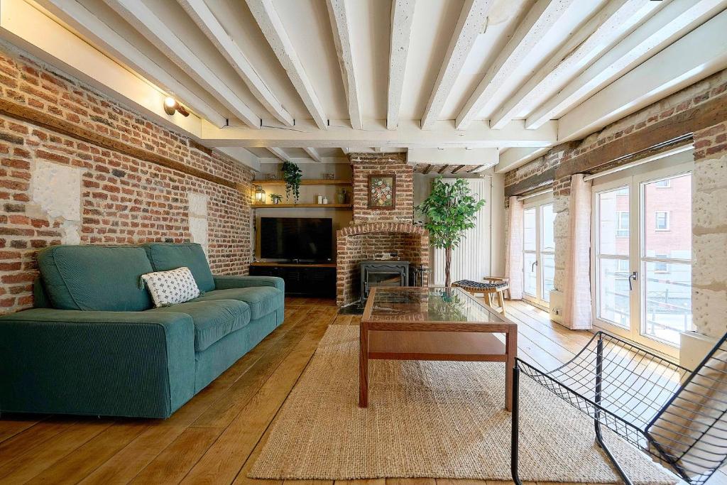 a living room with a blue couch and a brick wall at Old Town - Lovely typical house in Lille