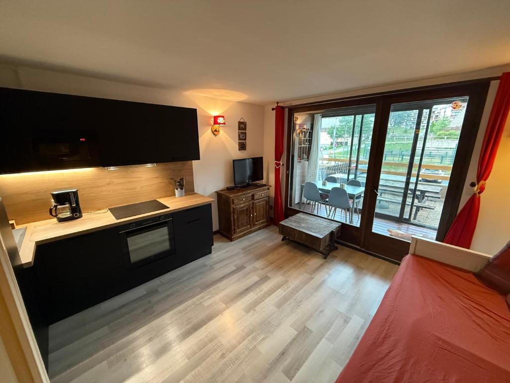 a living room with a large window and a television at Chez Arthur et Léa in La Joue du Loup