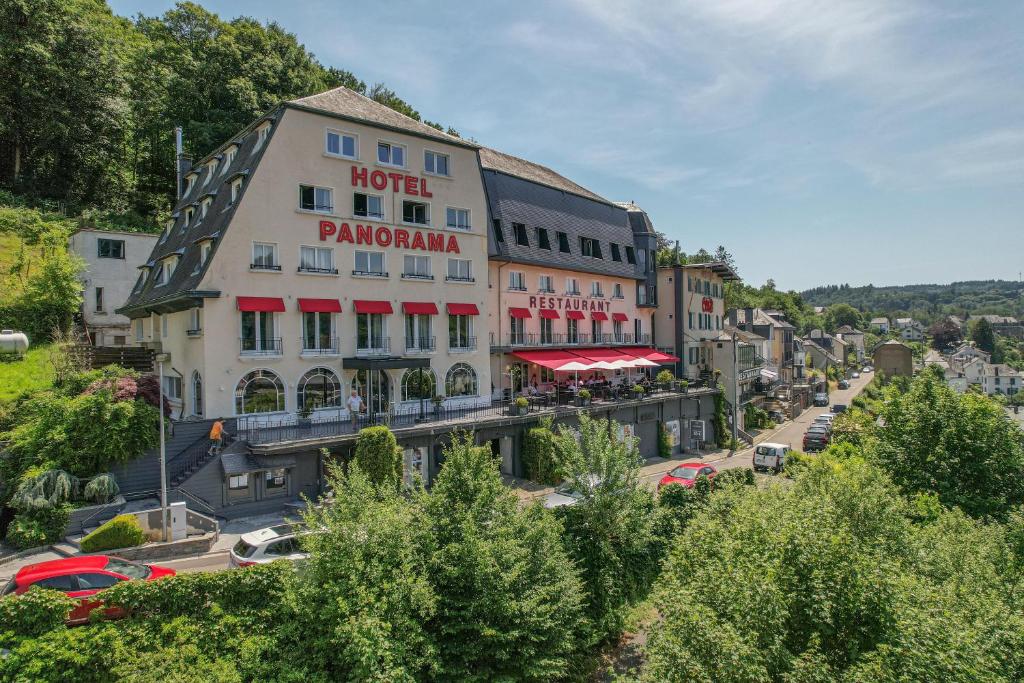 a hotel in the middle of a street with cars at Hôtel Panorama - Vue exceptionnelle sur la Semois in Bouillon