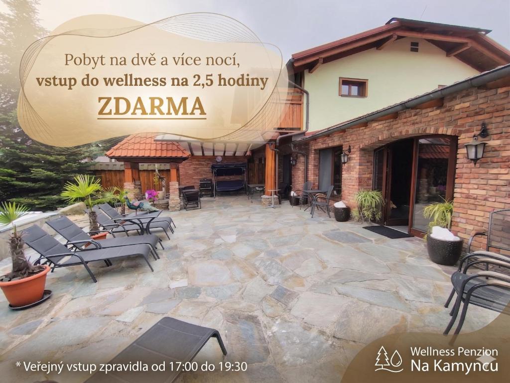 a stone patio with chairs and a building at Wellness Penzion Na Kamyncu in Jablunkov