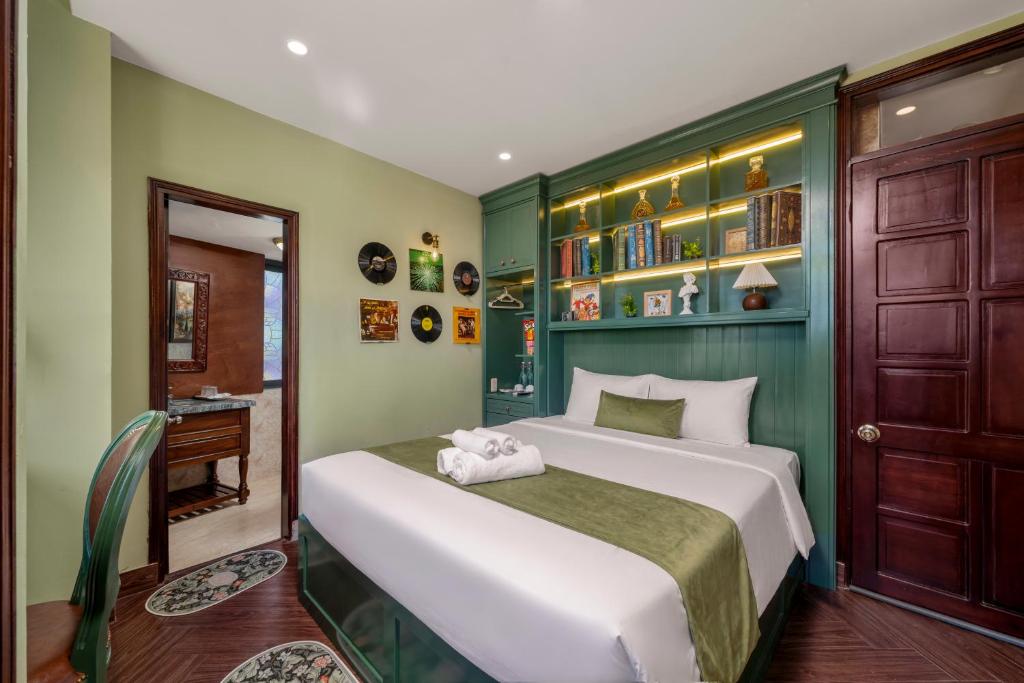 a bedroom with a large white bed with green walls at Vina Classic Hotel in Hue
