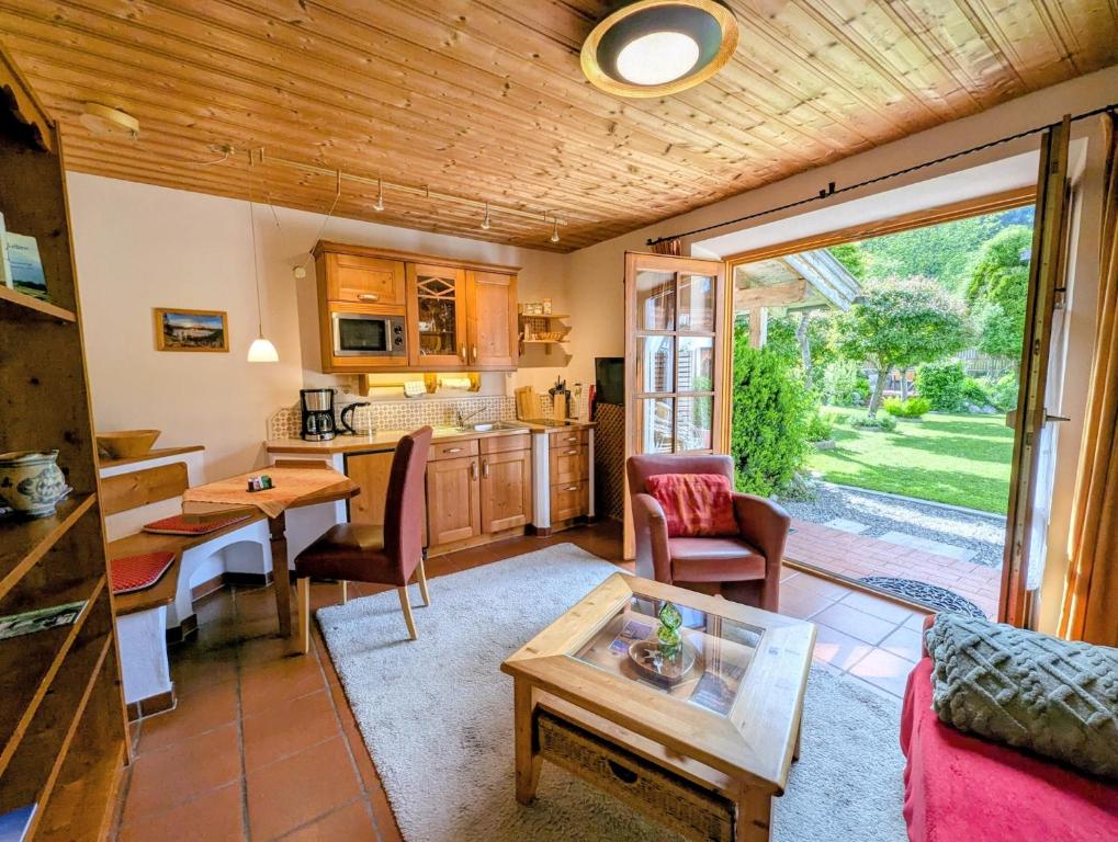 a living room with a table and a kitchen at Ferienwohnung Rösslstube in Ruhpolding