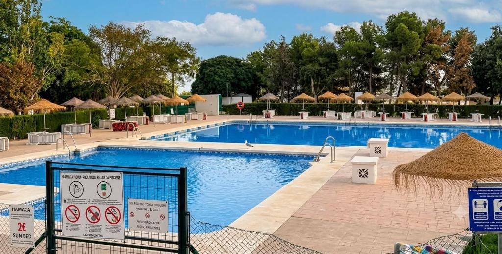 a pool with chairs and umbrellas at a resort at Hercules in Arroyo de la Miel