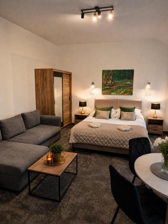 a living room with a bed and a couch at Gościniec u Bernackich in Smołdzino