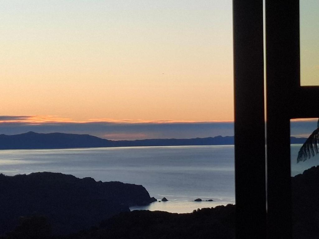 a view of a body of water at sunset at Totaranui Accommodation Chalet 2 in Tata Islands