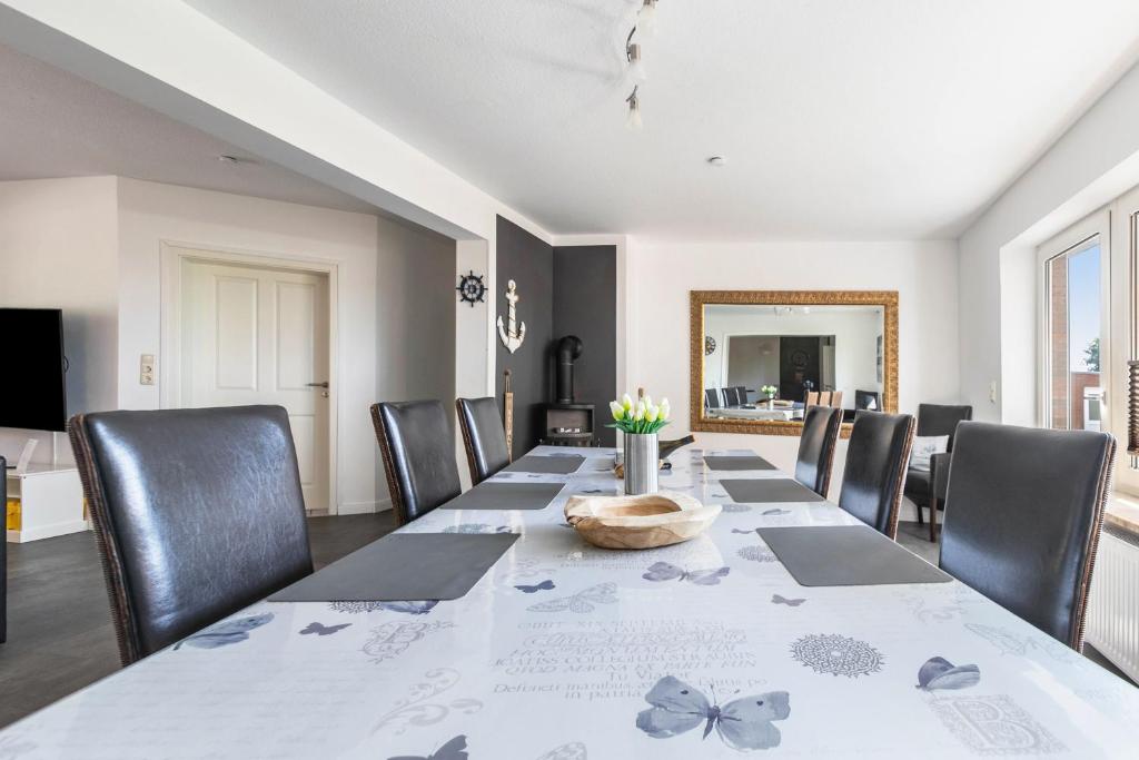a dining room with a long table and chairs at Fewo Freiraum mit großer Terrasse in Friedrichskoog