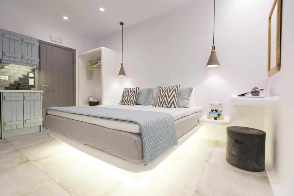 a white bedroom with a bed and a kitchen at Korali Palace Hotel in Naxos Chora