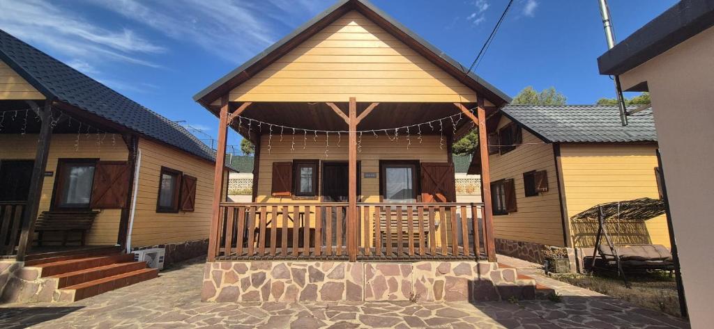 a log cabin with a porch and a deck at Las Cabañas del Bosque in Chiva