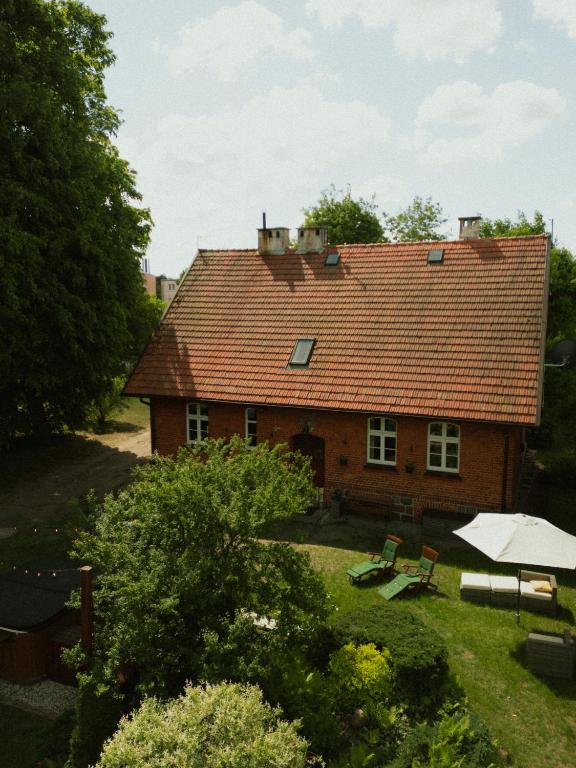a house with a red roof and benches in the yard at Pokrzepka in Spychowo