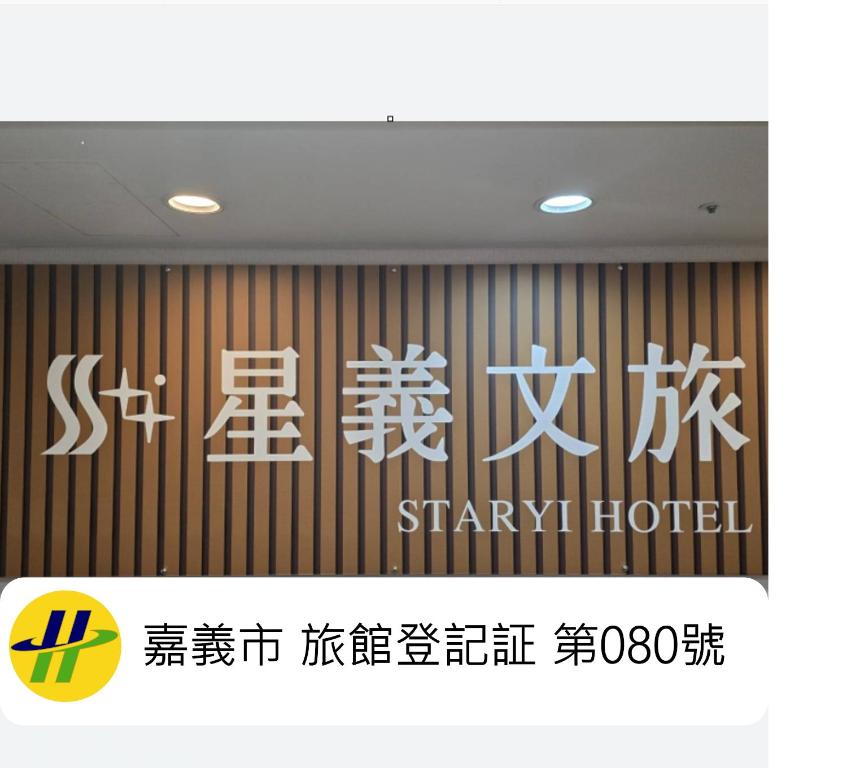 a sign for a starry hotel with writing on a wall at Xingyi Hotel in Chiayi City